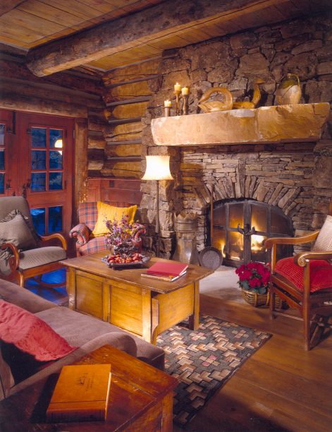 Rustic living room with natural stone fireplace, wood beams, and rustic furniture