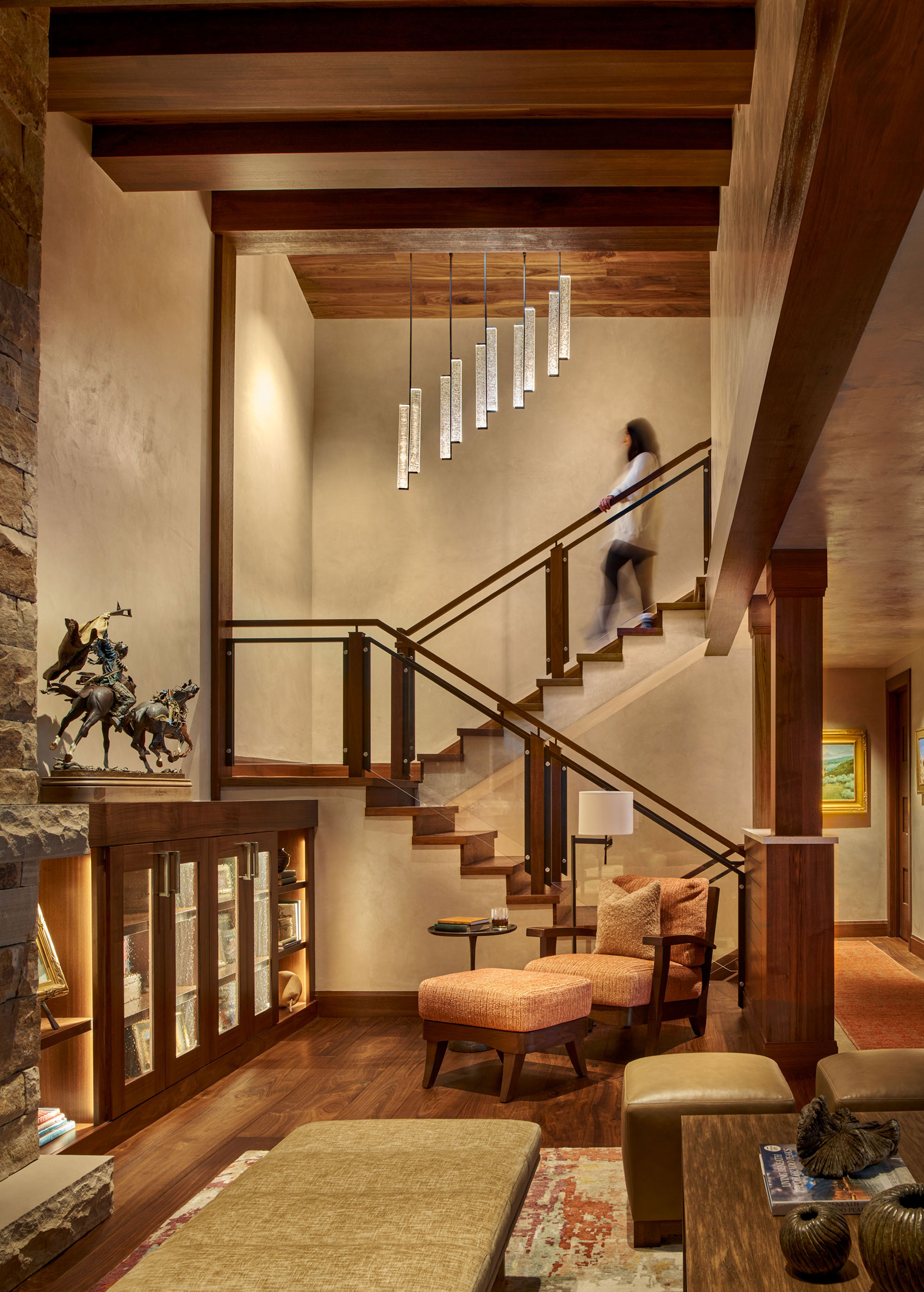 Focal staircase in living room with woman walking down the stairs